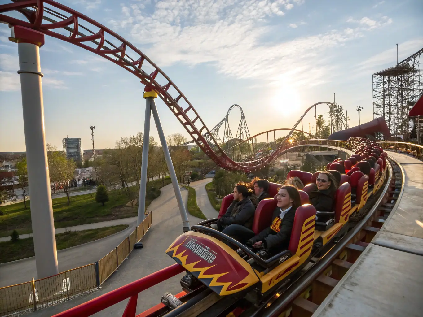 A high-speed roller coaster with steep drops and sharp turns, set against a clear blue sky. Riders are visible, expressing excitement and thrill.